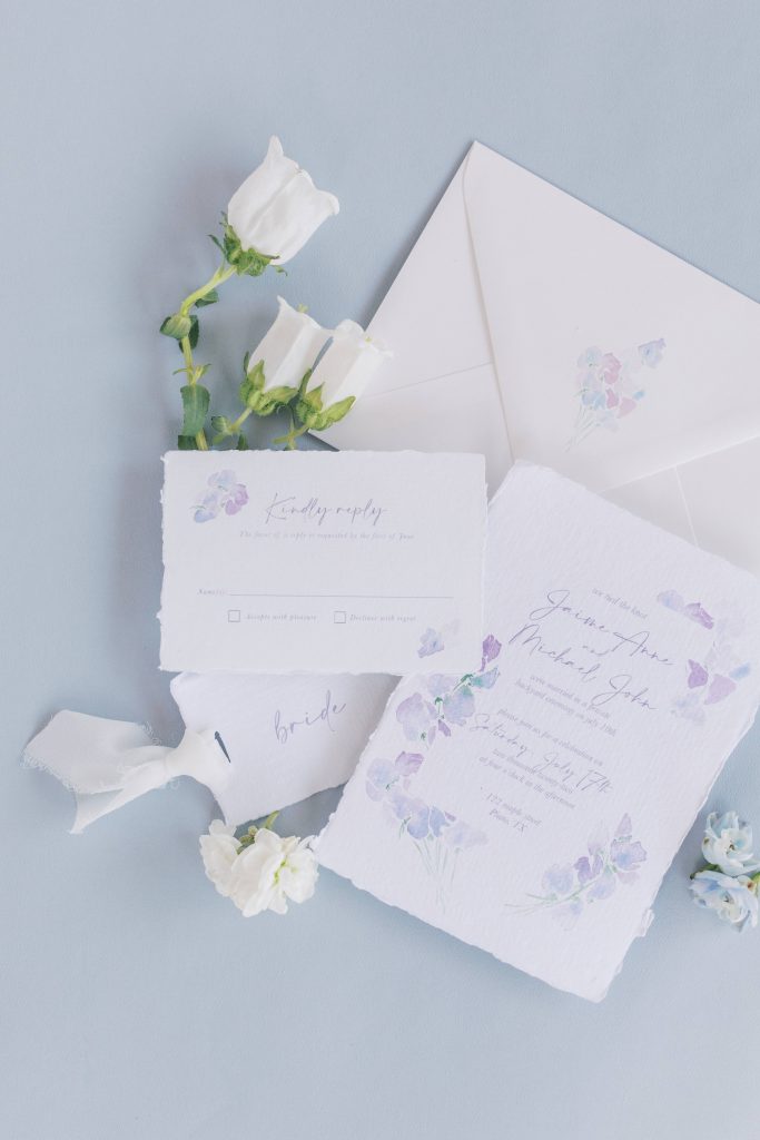 floral watercolor invitation styled with a handmade paper place card that says bride